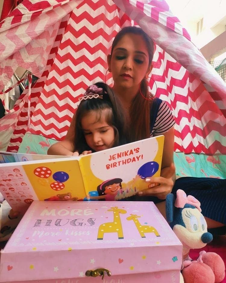 mom and daughter reading a book in the kids teepee tent