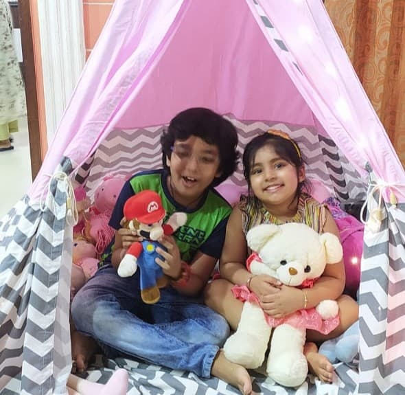 two kids enjoying a birthday party in their play teepee tent